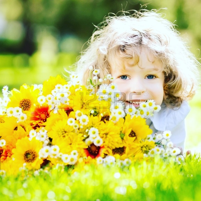 Photograph of young child sitting in flowers